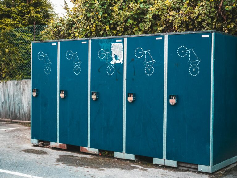 Outdoor blue portable toilet containers aligned in a row against a leafy backdrop. luxury toilet hire Scotland